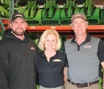 SERVPRO employees, Chandler, Brandy & Steve Knight, standing in front of air movers
