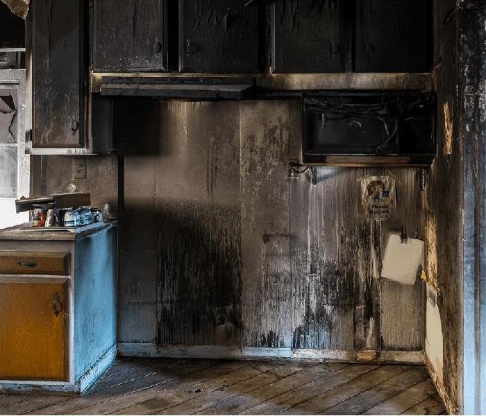 kitchen with blackened walls and cabinets and major fire damage