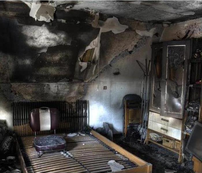 Bedroom with extensive fire damage.